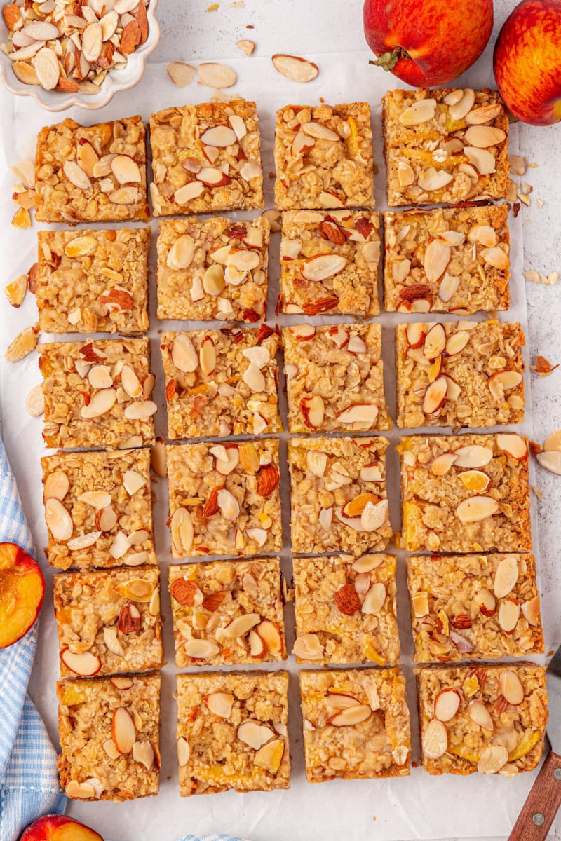 overhead view of sliced peach bars on a white surface