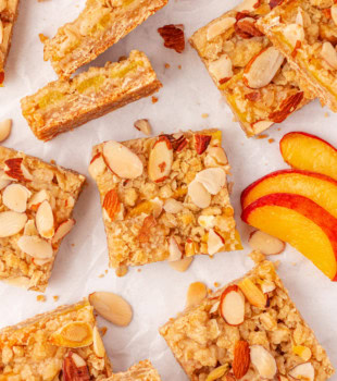 peach bars and peach slices scattered on a white surface