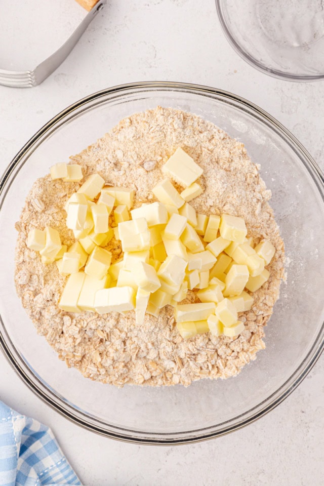 overhead view of cold, cubed butter added to dry ingredients for crust and crumb topping