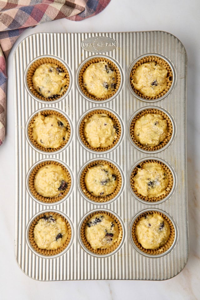 overhead view of blackberry muffins in a lined muffin pan ready to go into the oven