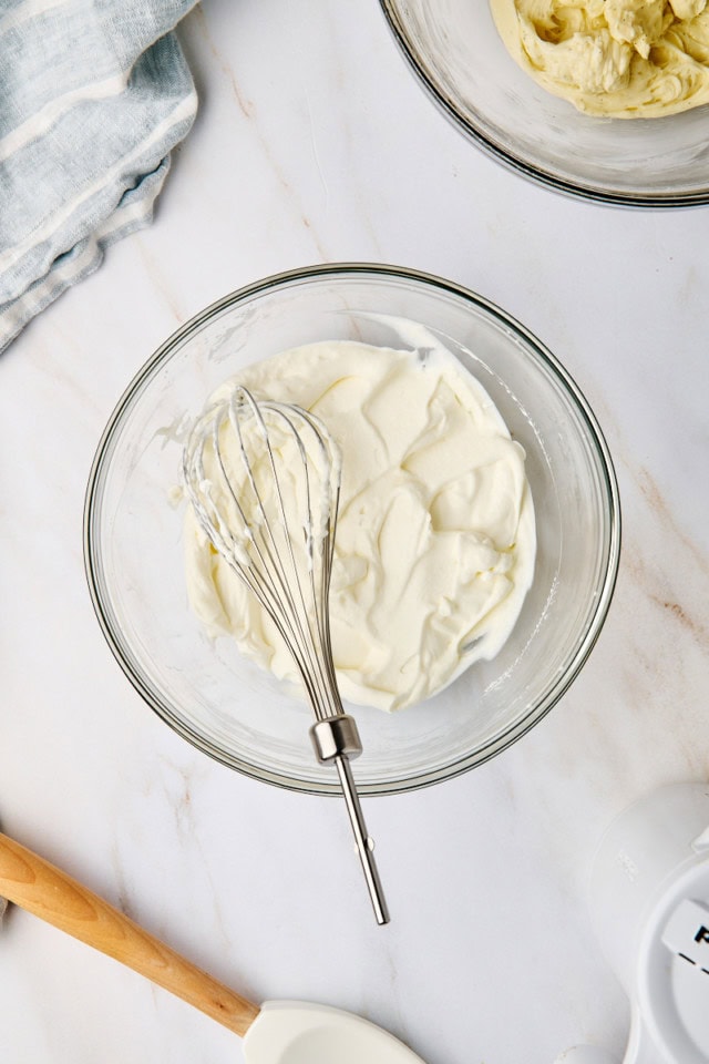 overhead view of whipped cream in a glass mixing bowl