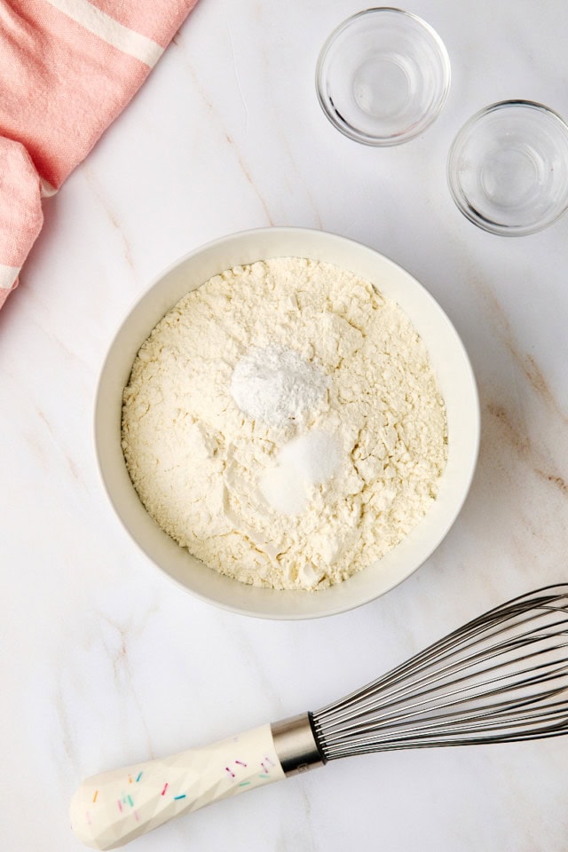 overhead view of flour, baking powder, and salt in a white bowl