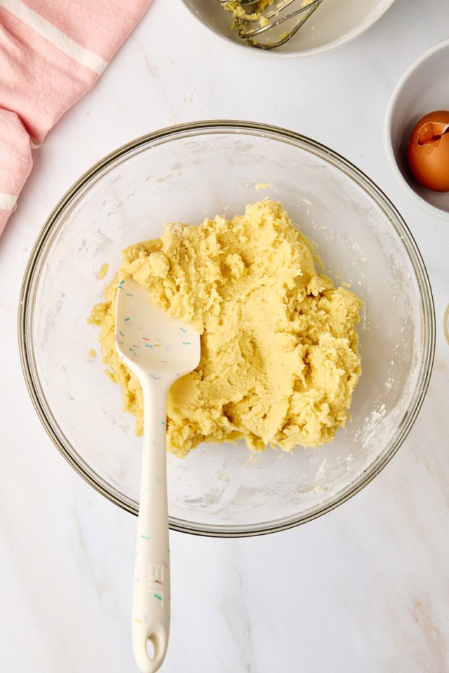 overhead view of mixed sugar cookie dough in a glass mixing bowl