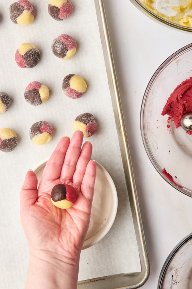 a rolled Neapolitan cookie dough ball in the palm of a hand