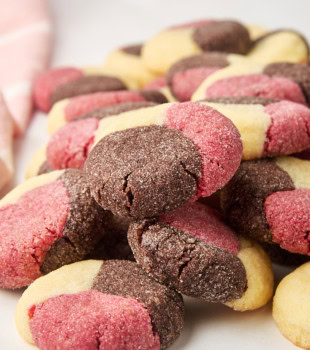 a stacked pile of Neapolitan cookies on a white surface