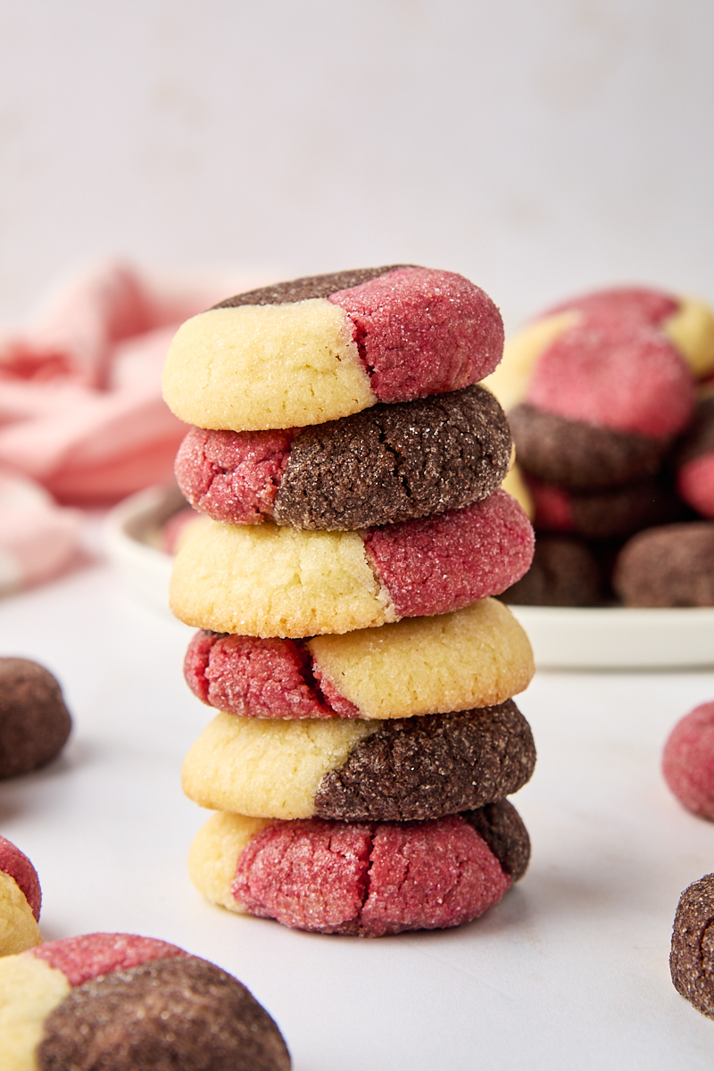 a stack of six Neapolitan cookies with more cookies in the background