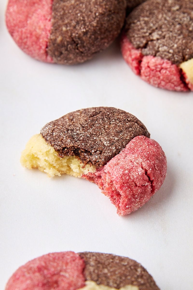 a Neapolitan cookie with a bite missing, surrounded by more cookies