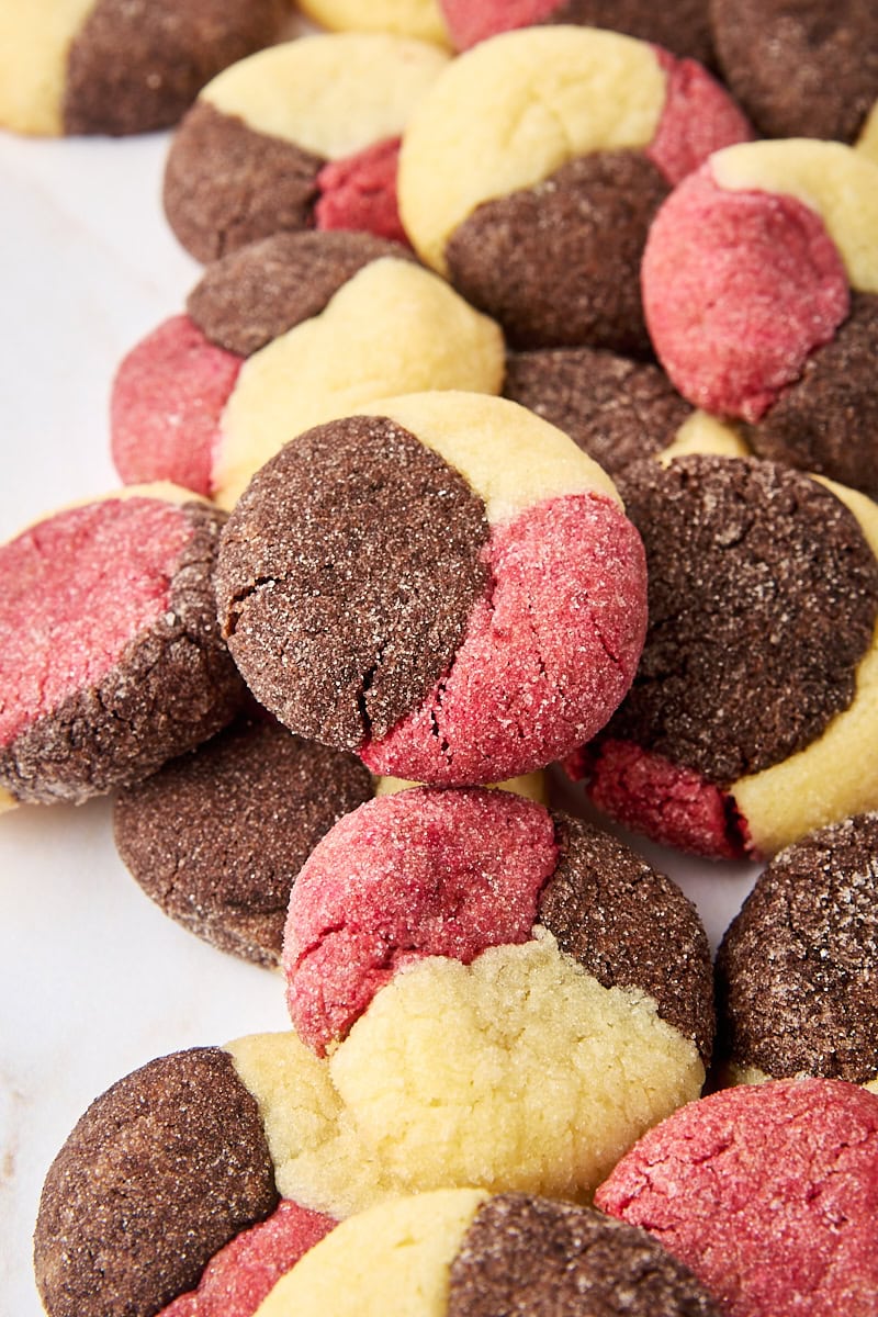 several Neapolitan cookies piled on a white surface