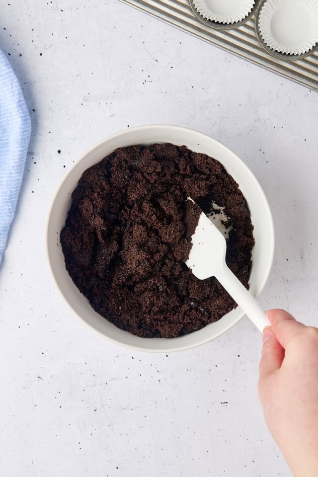 overhead view of Oreo cookie crust being mixed in a white bowl