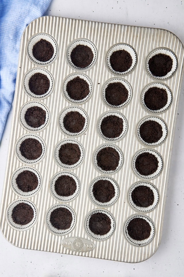 overhead view of Oreo cookie crust pressed into the bottoms of a mini muffin pan