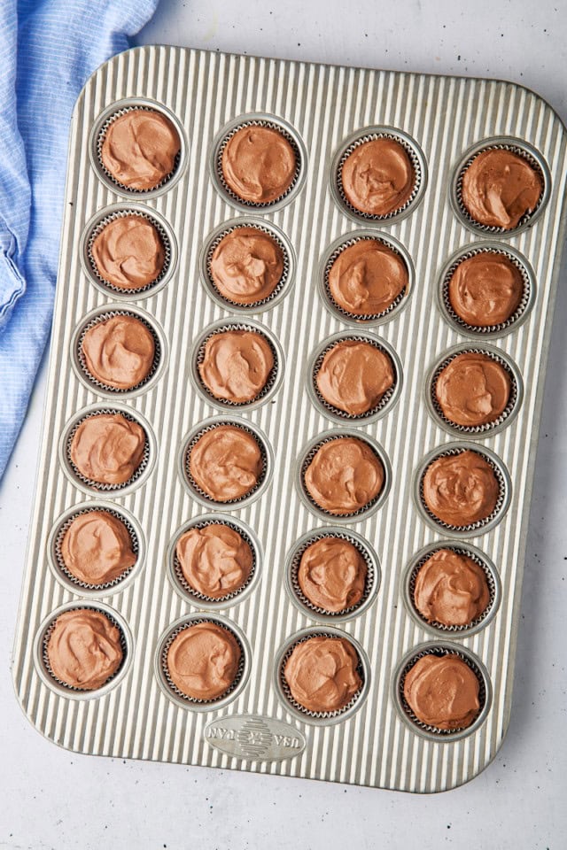 overhead view of mini no-bake chocolate cheesecakes in a mini muffin pan ready to be chilled before serving