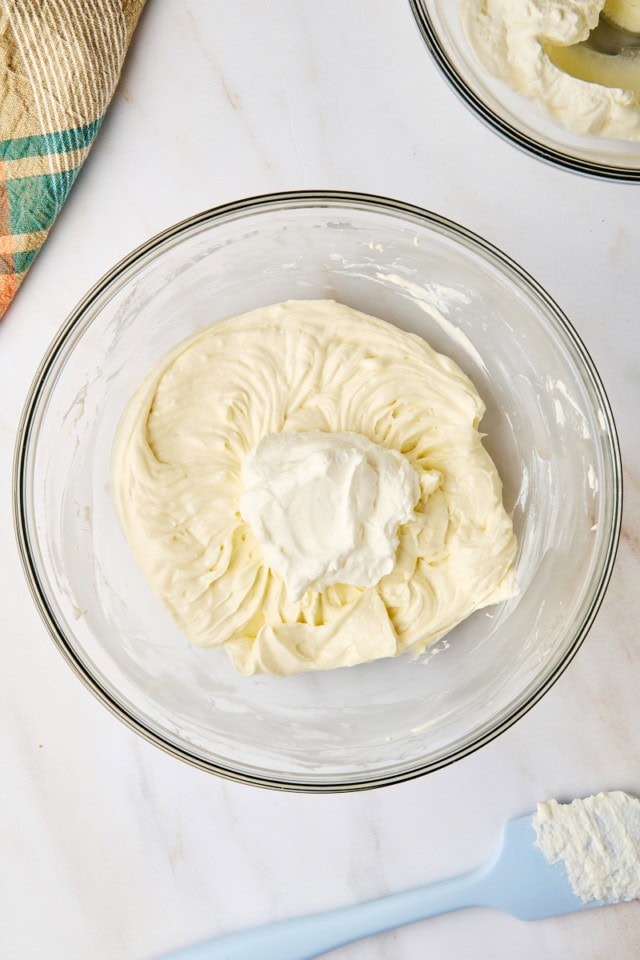 overhead view of whipped cream added to cream cheese mixture for no-bake cheesecake
