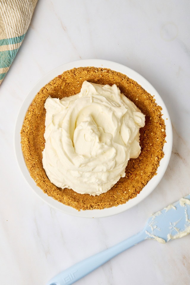overhead view of no-bake marshmallow cheesecake batter in a pie plate with a graham-pretzel crust