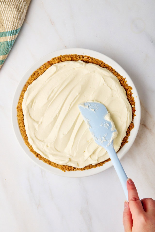 overhead view of no-bake marshmallow cheesecake batter being spread in a pie plate