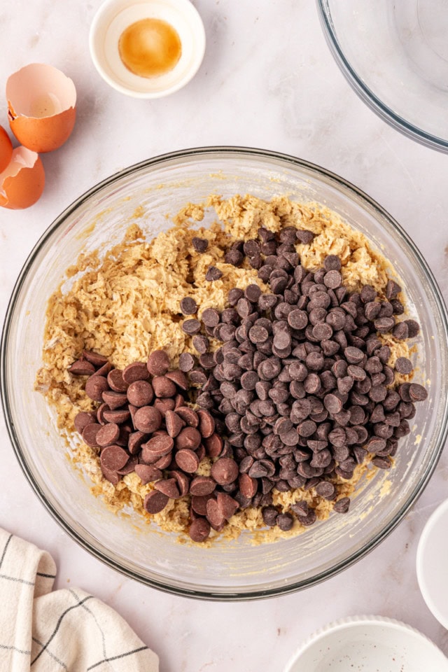 overhead view of chocolate chips added to brown sugar oatmeal cookie dough