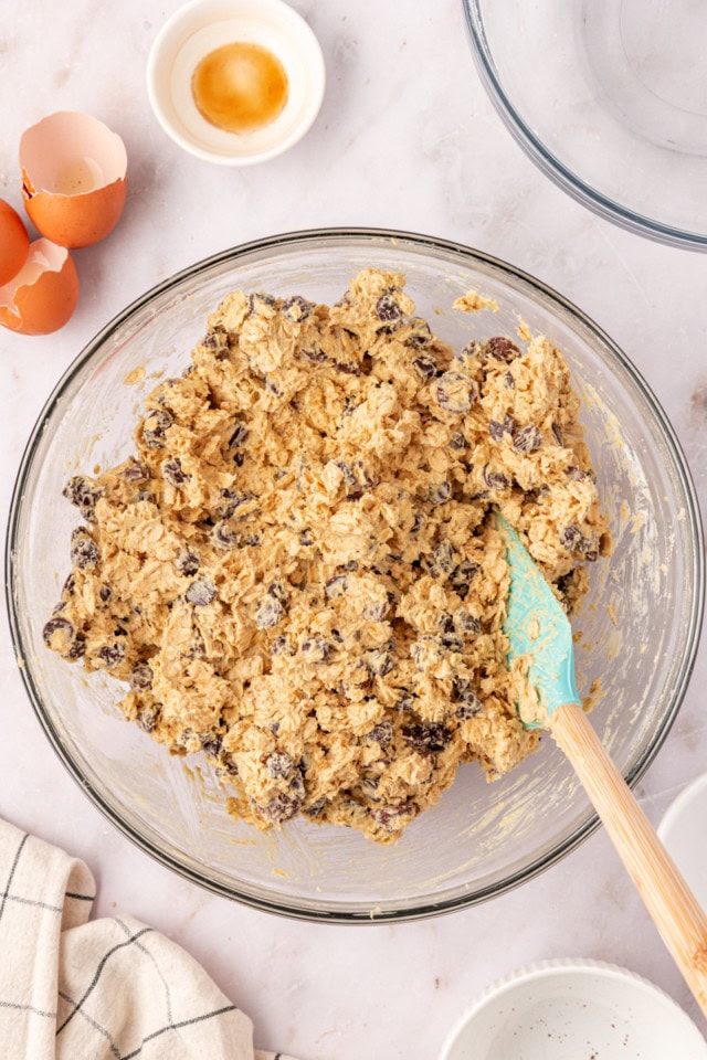 overhead view of brown sugar oatmeal chocolate chip cookie dough in a glass mixing bowl