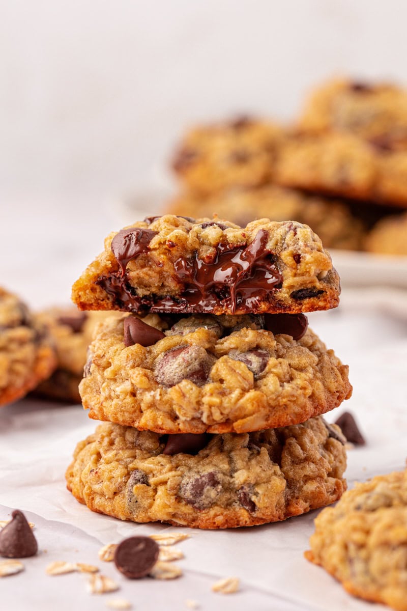 stack of three brown sugar oatmeal chocolate chip cookies with a bit missing from the top cookie