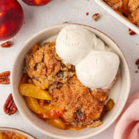 overhead view of a serving of ginger peach cobbler topped with ice cream