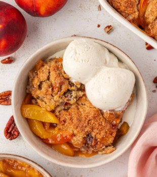 overhead view of a serving of ginger peach cobbler topped with ice cream