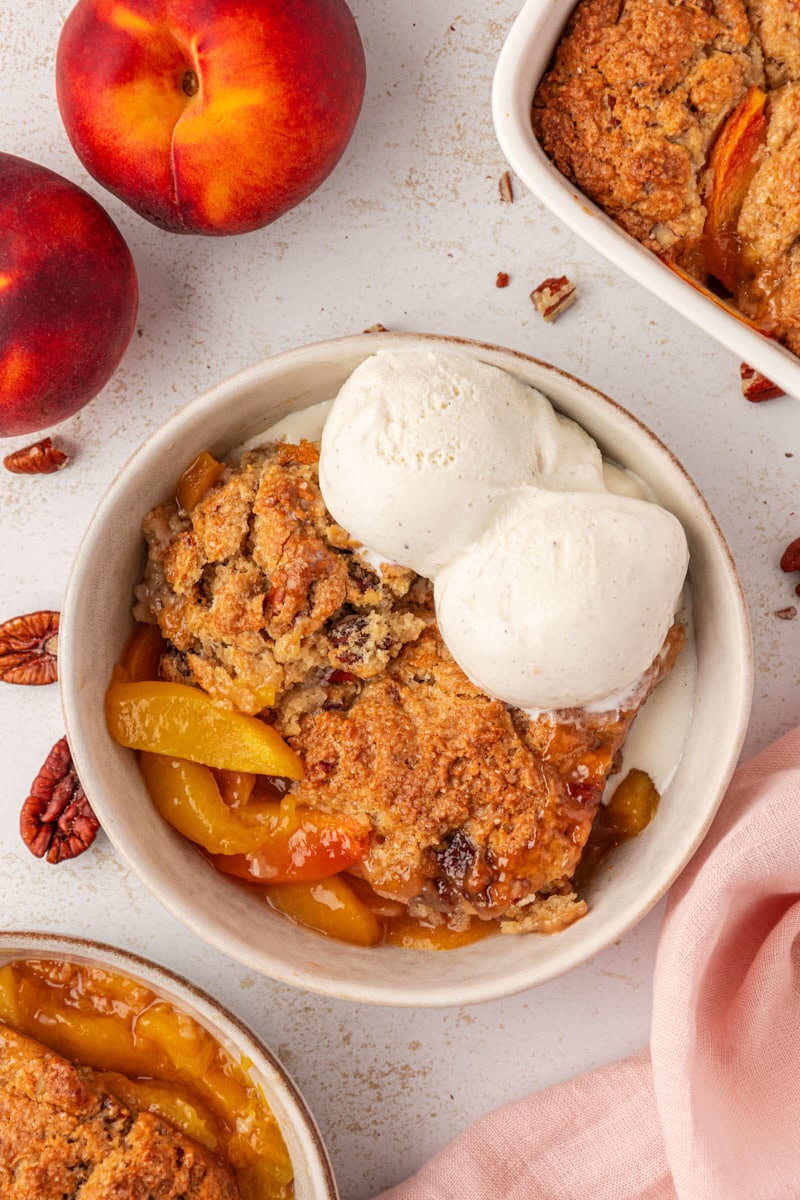 overhead view of a serving of ginger peach cobbler topped with ice cream