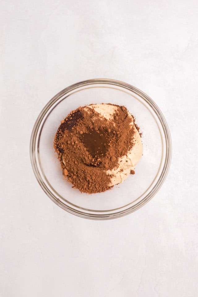 overhead view of cocoa powder, melted chocolate, and espresso powder added to cupcake batter