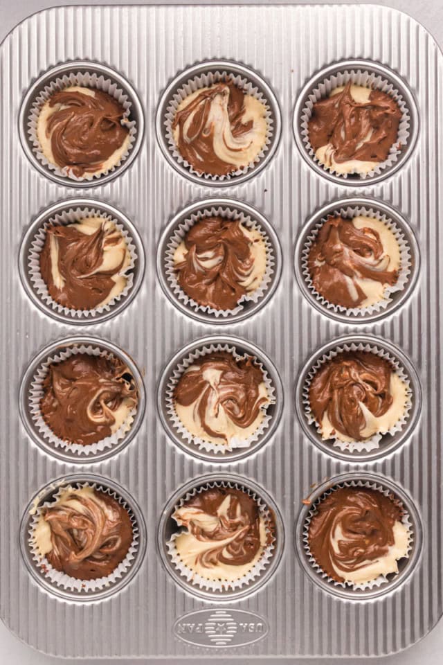 overhead view of marble cupcakes in a muffin pan ready to go into the oven
