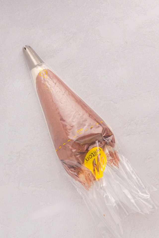 overhead view of chocolate and vanilla buttercream frostings in a piping bag