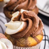 a marble cupcake on a wire rack surrounded by more cupcakes