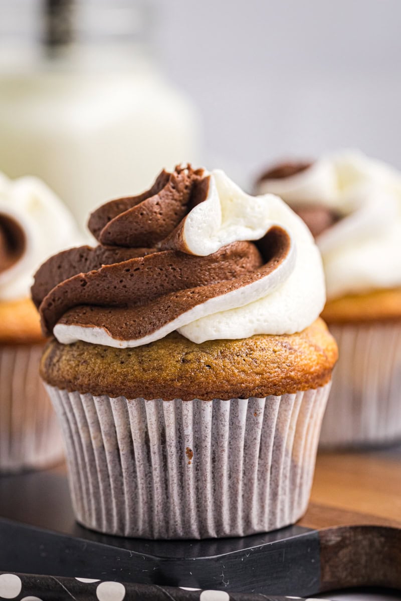 close-up of a marble cupcake on a wooden surface with more cupcakes partially visible in the background