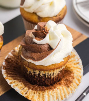 an unwrapped marble cupcake on a wooden surface