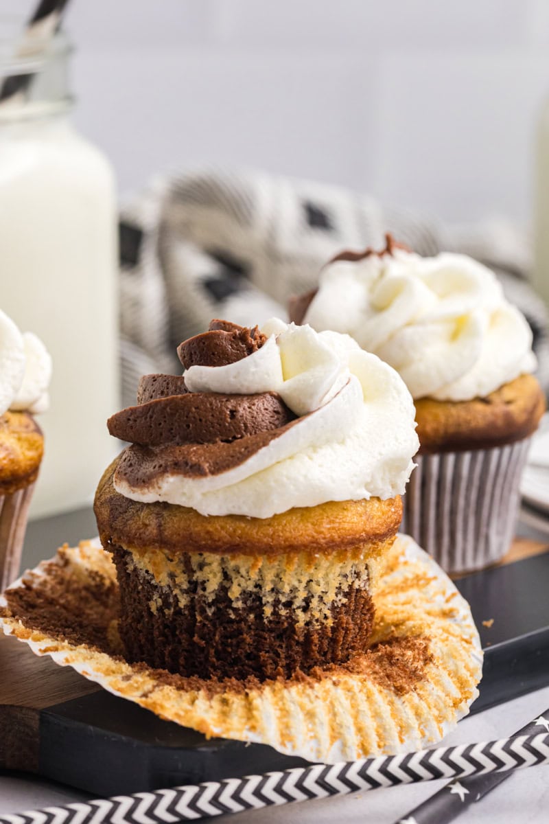 an unwrapped marble cupcake on a black surface with more cupcakes in the background