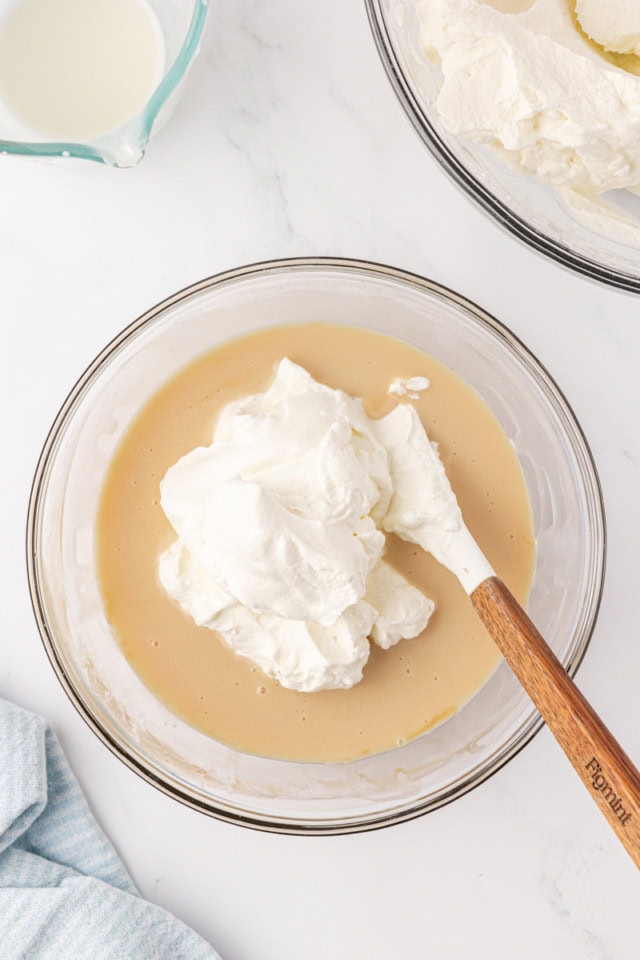 overhead view of whipped cream added to condensed milk mixture for stracciatella ice cream