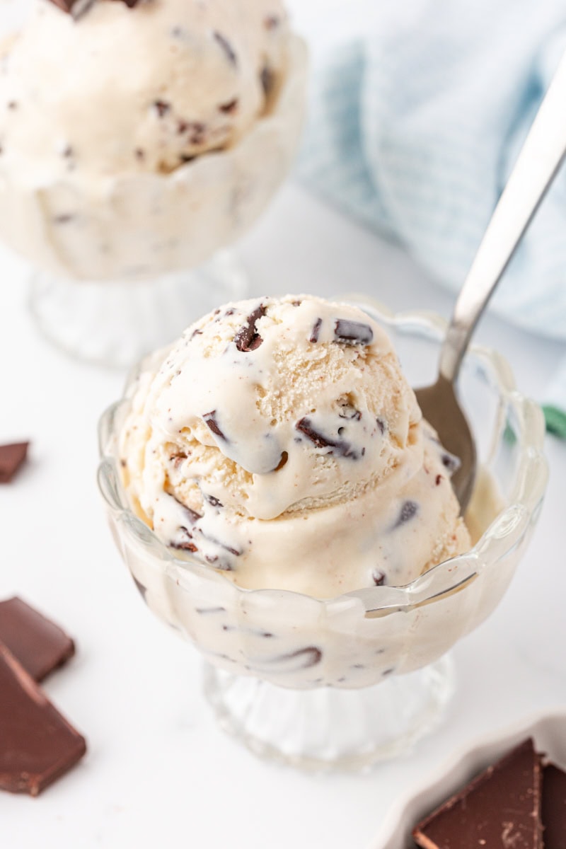 stracciatella ice cream in a glass bowl with a spoon resting inside