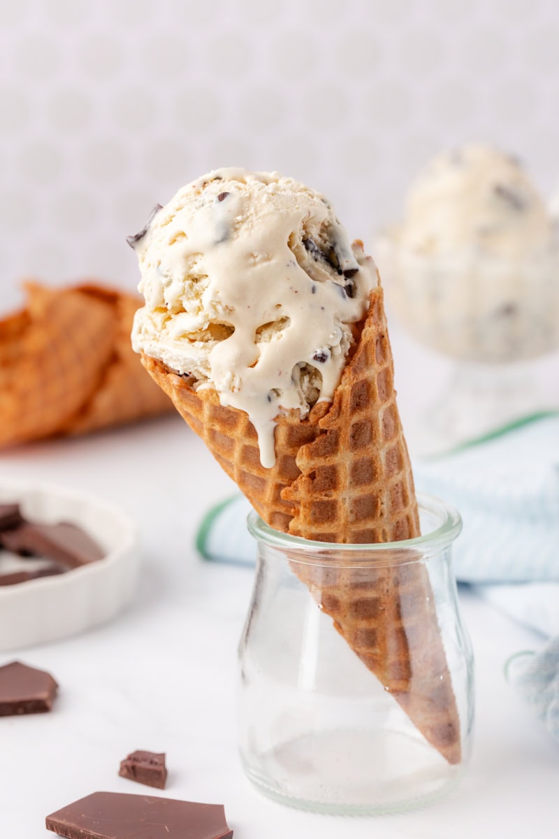 stracciatella ice cream in a waffle cone resting inside a small glass