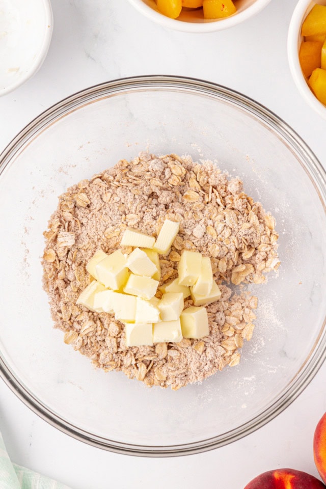 overhead view of cubes of butter added to crisp topping mixture