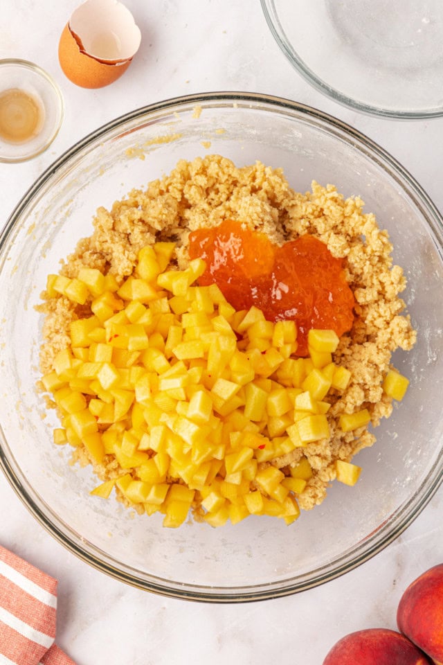 overhead view of chopped peaches and peach preserves added to cookie dough