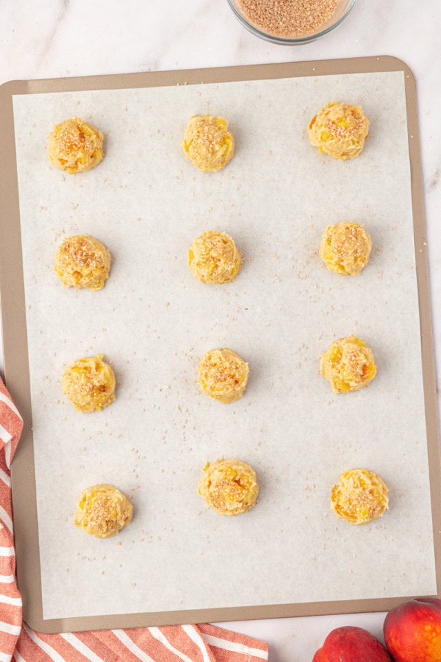 overhead view of peach cookie dough on a lined cookie sheet ready to go into the oven