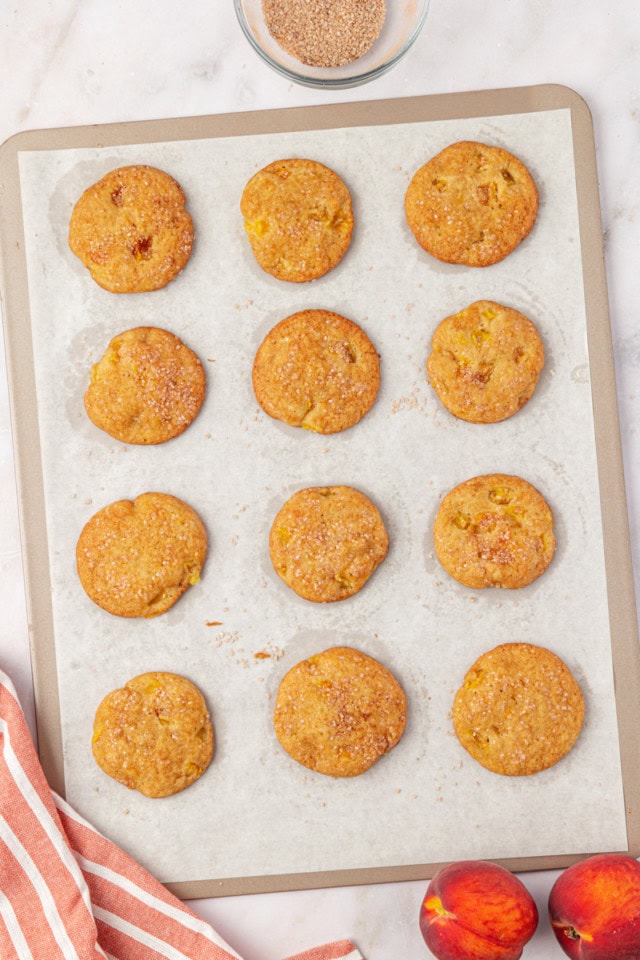 overhead view of freshly baked peach cookies on a lined cookie sheet