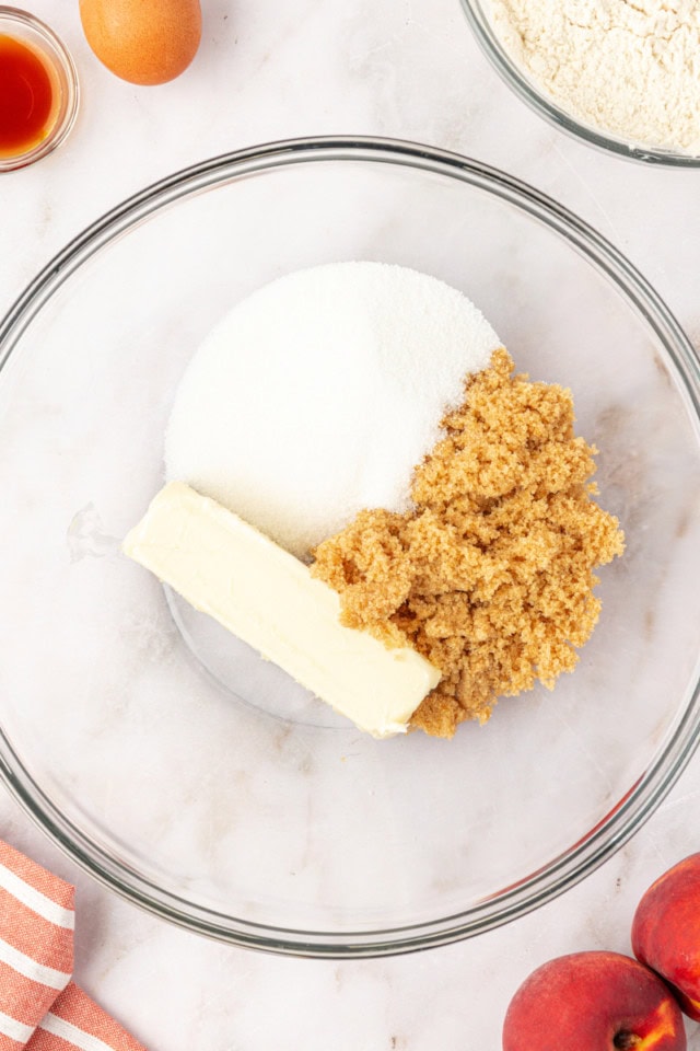 overhead view of butter, sugar, and brown sugar in a glass mixing bowl