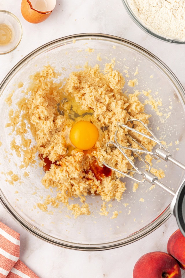 overhead view of egg and vanilla extract added to creamed butter and sugars