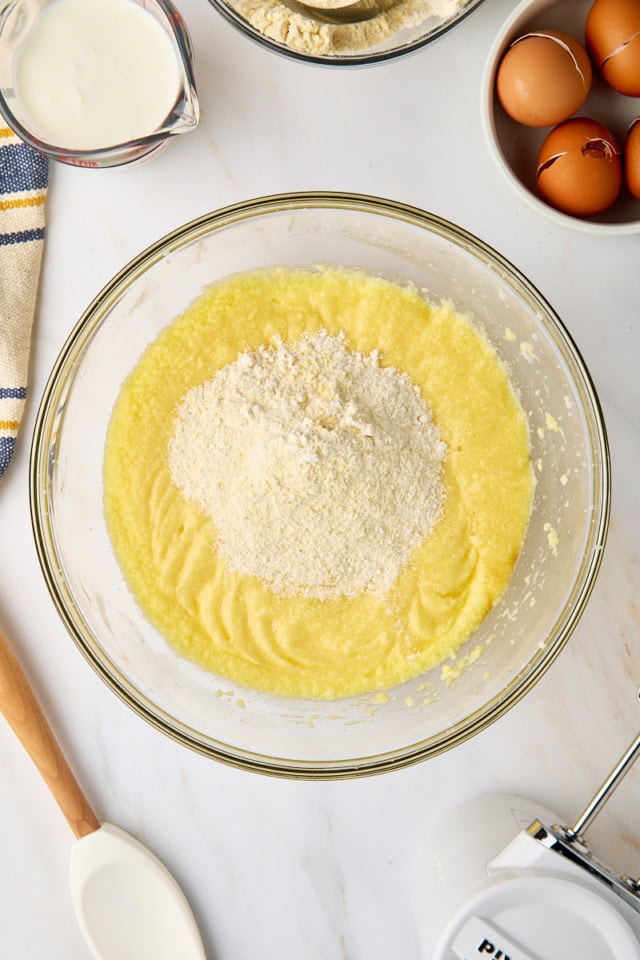 overhead view of dry ingredients added to wet ingredients for cornmeal pound cake