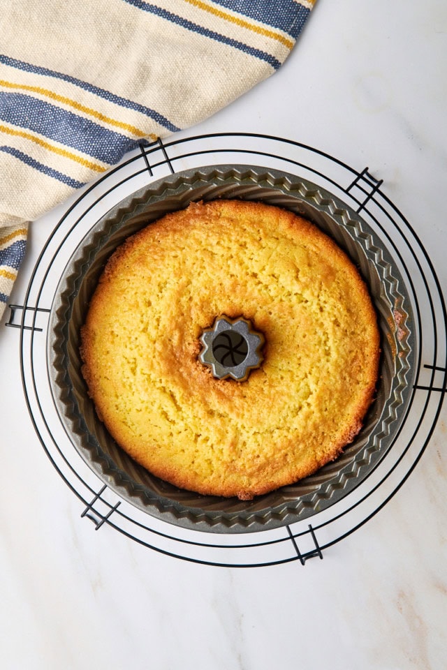 overhead view of freshly baked cornmeal pound cake in a Bundt pan on a wire rack