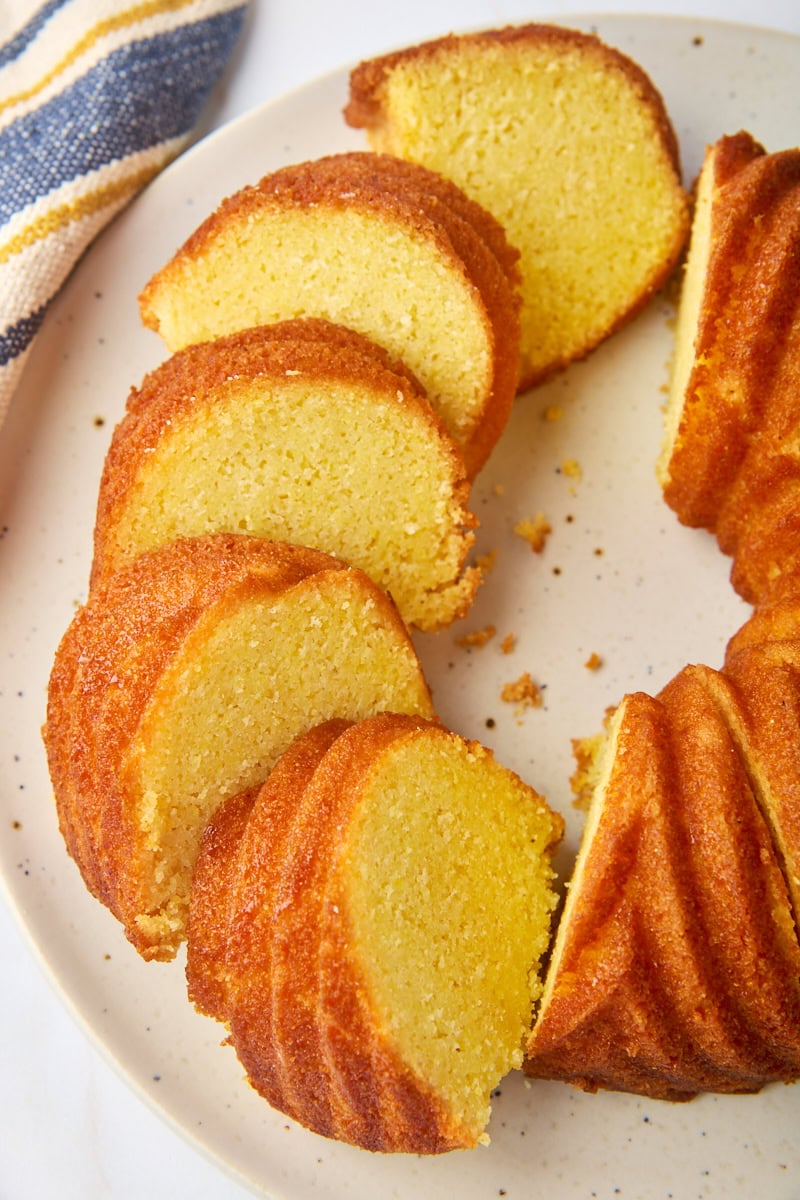 partially sliced cornmeal pound cake on a white cake plate