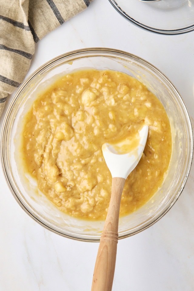 overhead view of banana bread batter in a glass mixing bowl