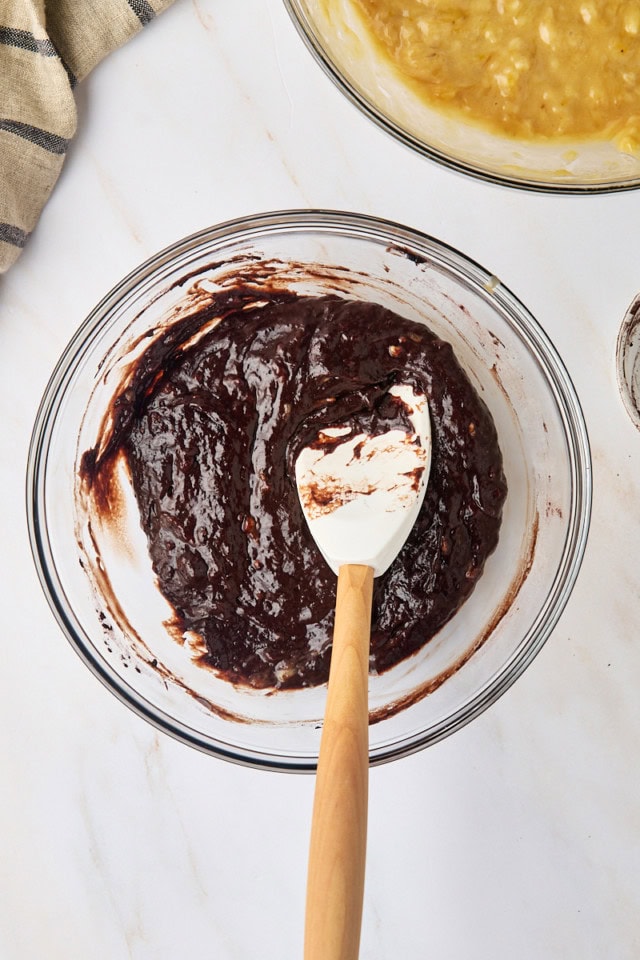overhead view of chocolate banana bread batter in a glass mixing bowl