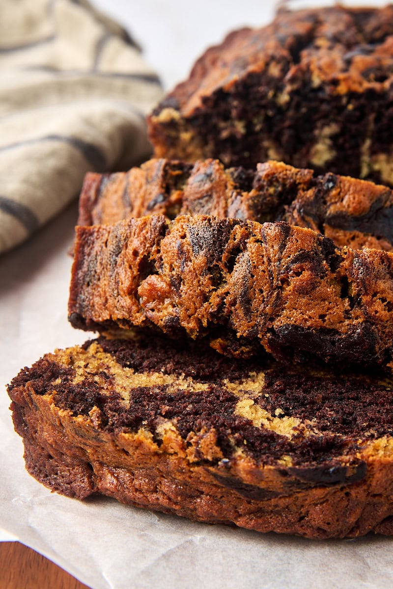 overlapping slices of marbled chocolate banana bread on parchment paper