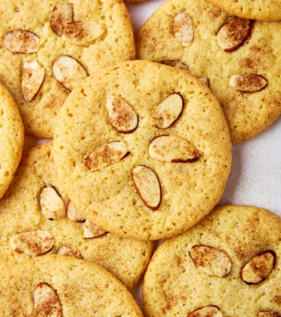 several sand dollar cookies piled and stacked on a white surface