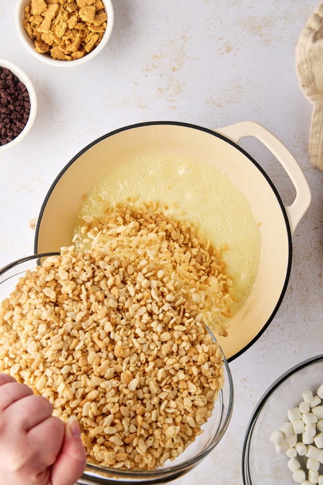 overhead view of rice cereal being poured into melted butter and marshmallow mixture
