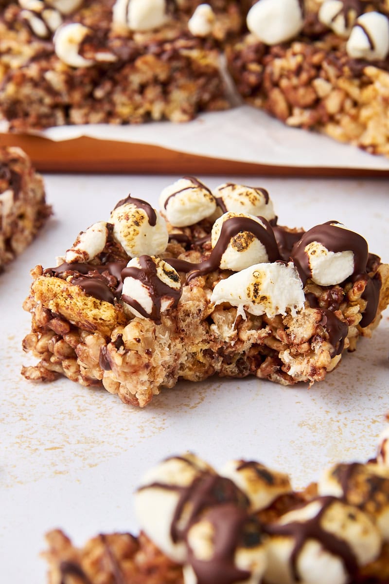 a s'mores rice crispy treat with a bite missing, surrounded by more bars