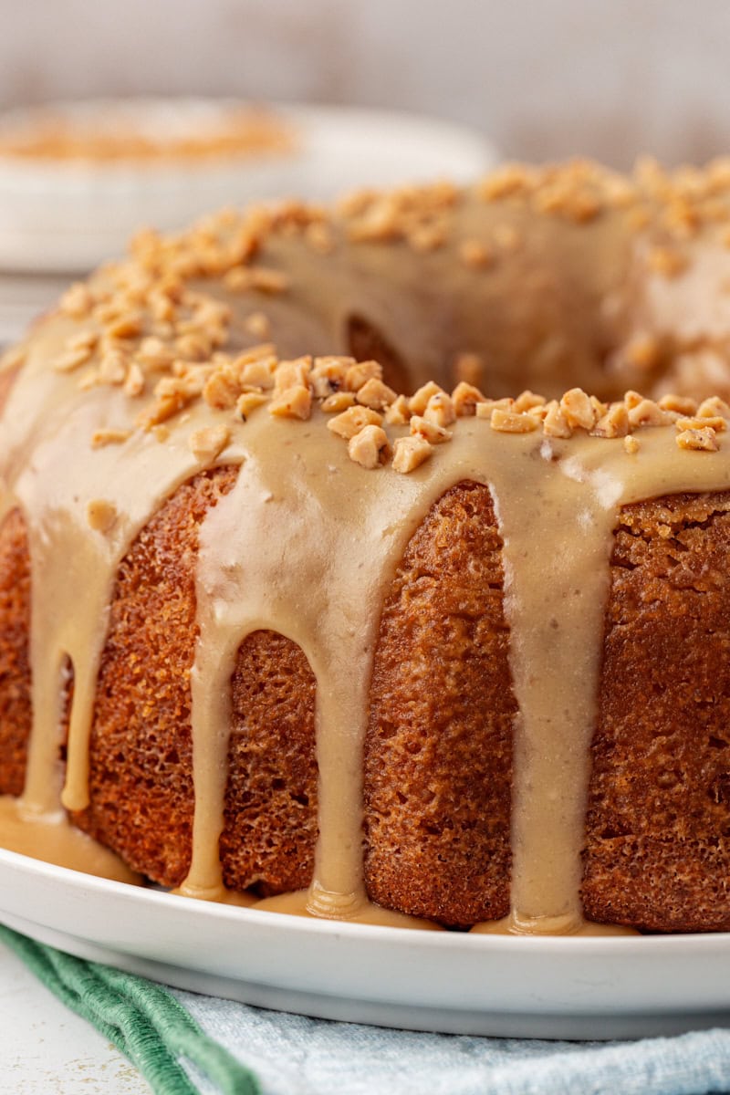 caramel swirl Bundt cake topped with caramel glaze on a white cake plate